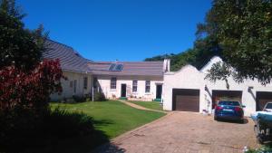 una casa blanca con un coche aparcado en la entrada en Seven Gables, en Port Elizabeth