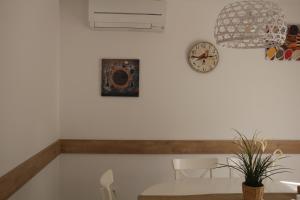 comedor con mesa y reloj en la pared en Apartamentos Homelife Roca Tarpeya en Toledo