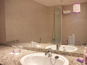 
a bathroom with a sink, mirror, and bathtub at Hotel Servigroup Marina Mar in Mojácar
