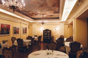 een eetkamer met tafels en stoelen en een plafond bij British Club Lviv in Lviv