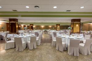 a banquet hall with white tables and white chairs at Hotel Europa in Albacete