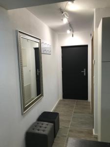 a hallway with a mirror and a stool and a door at Einliegerwohnung mit Terrasse in Friedrichshafen