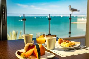 a table with breakfast food and a view of the ocean at Hôtel Restaurant Splendid Camargue in Le Grau-du-Roi