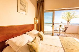 a bedroom with a bed with a view of the ocean at Hôtel Restaurant Splendid Camargue in Le Grau-du-Roi +24 photos