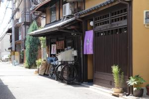 uma bicicleta está estacionada fora de um edifício em Guest House Sawaragi em Quioto
