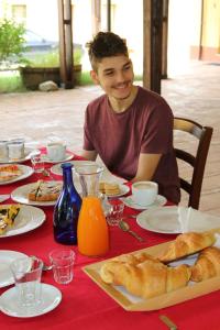 un joven sentado en una mesa con comida en Il Campetto Country House, en Senigallia