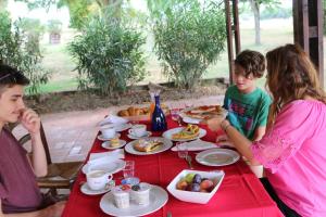 a group of people sitting at a table eating food at Il Campetto Country House in Senigallia