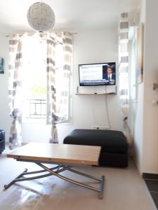 een woonkamer met een tafel en een bank bij Le Charleston 3p 5 minutes Disney Parking gratuit Terrasse in Chessy