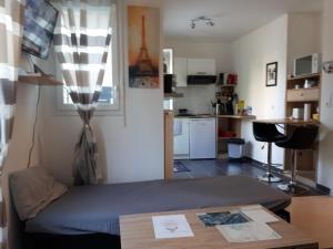 een kleine kamer met een bed en een keuken bij Le Charleston 3p 5 minutes Disney Parking gratuit Terrasse in Chessy