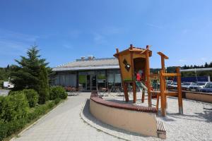 a playground in front of a building at Hotel Ravna Gora in Ravna Gora