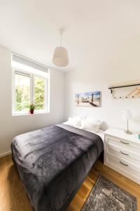 a white bedroom with a large bed and a desk at B&B Daya in Kessel-Lo