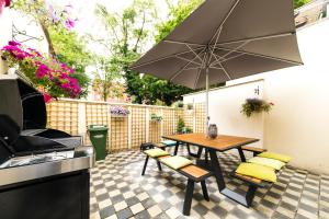 een patio met een tafel en stoelen en een parasol bij B&B Daya in Kessel-Lo