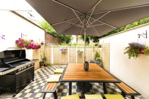 a patio with a wooden table and an umbrella at B&B Daya in Kessel-Lo