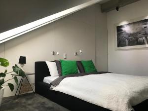 een slaapkamer met een bed met groen en wit bij Apartament "WARSZAWA" in Warschau