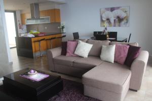 ein Wohnzimmer mit einem Sofa und einer Küche in der Unterkunft Villa Girasol in Arco da Calheta