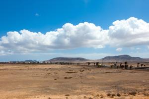 a desert field with mountains in the background at TAO El Cotillo - VV in El Cotillo