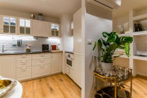 kuchnia z białymi szafkami i doniczką w obiekcie Clavature LuxuryApartment w Bolonii