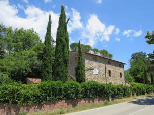 un bâtiment avec des cyprès et un mur en briques dans l'établissement Gabellino Di Sotto, à Boccheggiano