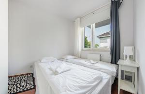 1 dormitorio con 2 camas y ventana en Apartamenty Sun & Snow Bursztynowy, en Władysławowo