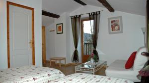 Schlafzimmer mit einem Bett, einem Tisch und einem Fenster in der Unterkunft Chambres d'hôtes La Hulotte 69 in Villechenève