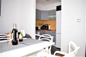 cocina blanca con mesa y sillas blancas en Apartament Fibra Cortado, en Rybnik