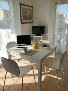 a white table with a laptop and chairs in a room at Palais des domes in Nice