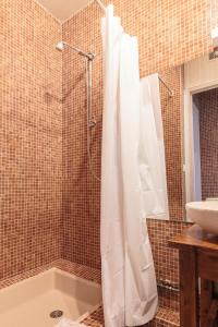 baño con ducha con cortina blanca en Villa Georges en Foix