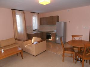 a living room with a kitchen and a table and chairs at Royal House Apartments TMF in Pamporovo