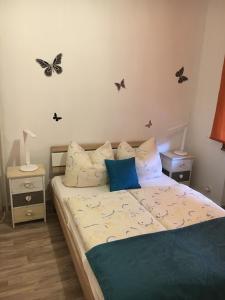 ein Schlafzimmer mit einem Bett mit Schmetterlingen an der Wand in der Unterkunft Hotel Lindenhof L1 in Bad Sachsa