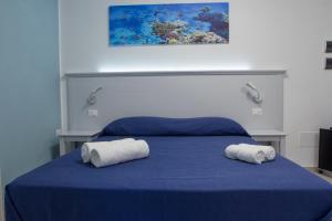 a bedroom with a blue bed with two towels on it at La Tonnara B&B in Palmi
