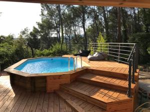 una piscina en una terraza de madera con una valla en L'AMANDIER, en Flayosc