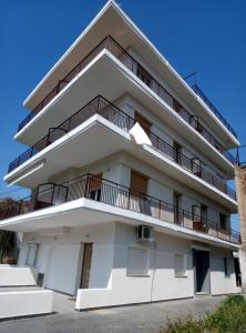 a building with balconies on the side of it at Pure BLISS Luxury Beachfront Apartment with Panoramic Sea Views, Electric BBQ and More in Agia Triada