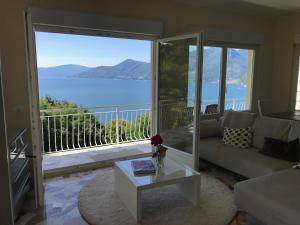 een woonkamer met een bank en uitzicht op de oceaan bij Moderne Ferienwohnung mit Traumseeblick Lago Maggiore in Luino