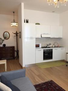 un soggiorno con cucina e armadietti bianchi di Elegant Apartment a Vicenza