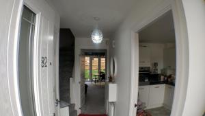 a hallway leading to a kitchen with a chandelier at AdB in Hemel Hempstead