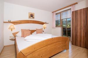 Un dormitorio con una gran cama de madera y una ventana en Fewo an der Seepromenade en Pertisau