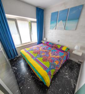 a bedroom with a bed with a colorful comforter at Appartamento Silvy in Riva del Garda