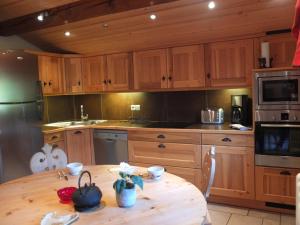 a kitchen with wooden cabinets and a wooden table at Edelweiss in Les Gets