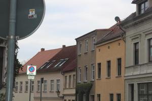 uma fila de edifícios com um sinal de rua à frente em Dompanorama- Luxuriöse FeWo em Havelberg