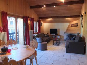 a living room with a wooden table and a couch at Edelweiss in Les Gets