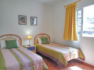 a bedroom with two beds and a window at Vv Casa Conchi in Alojera