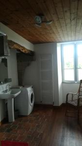 ein Badezimmer mit einem Waschbecken und einer Waschmaschine in der Unterkunft Gîte de Lolotte et Gégé in Audeux