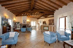 a living room with blue chairs and a fireplace at Corte In Fiore in Ardea