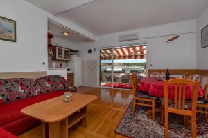 sala de estar con sofá rojo y mesa en Apartments Roza, en Makarska