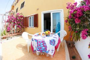 a table and chairs on a patio with flowers at Boteto Tamtama Apartments in Sal Rei