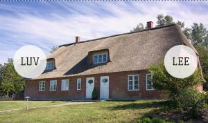 une grande maison en briques avec deux grands miroirs. dans l'établissement Schleusenwärter LUV, à Neukirchen