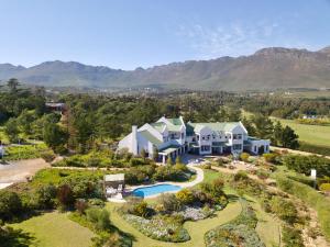 einen Luftblick auf ein großes Haus mit einem Pool in der Unterkunft Wind-Rose Guest House in Gordonʼs Bay