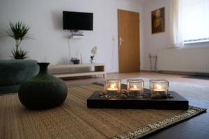 a living room with a vase and candles on a table at Natur und Erlebnis in Langen