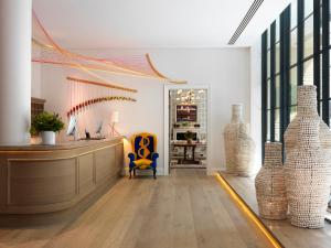 a lobby with a reception desk and vases at Ham Yard Hotel, Firmdale Hotels in London