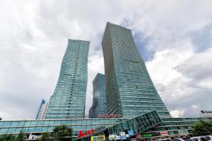 three tall buildings in a city with a cloudy sky at Studio on Dostyq Street 5 floor 25 in Astana